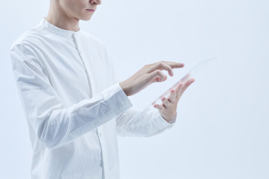 Person interacting with a transparent digital tablet, symbolizing technology and futurism.